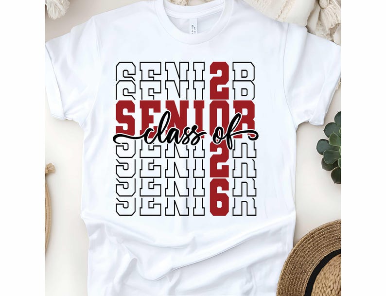 May include: White t-shirt with the words "SENIOR class of 2026" in a stacked design. The word "SENIOR" is in a bold red font, while the rest of the text is in black. The shirt is a classic crew neck.