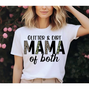Pode incluir: Camiseta branca com o texto "Glitter & Dirt Mama of both" em preto com uma estampa de leopardo e um padr&atilde;o de camuflagem atr&aacute;s do texto.