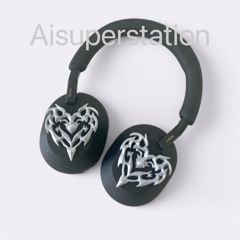 May include: Black over-ear headphones with a silver heart-shaped design on each earcup. The headphones have the word "SONY" printed on the side.