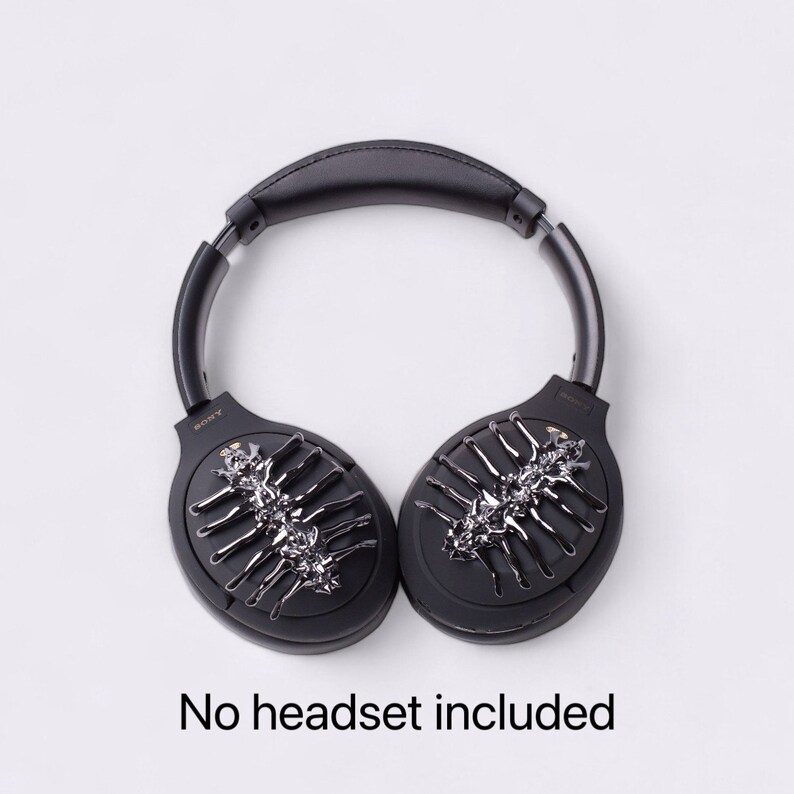 May include: Black headphones with a silver and black decorative design on each earcup. The text "SONY" is visible on the left earcup. "No headset included" is written below the headphones.
