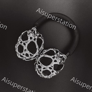 May include: Silver headphones with a black headband. The earcups have a unique, organic, and textured design.