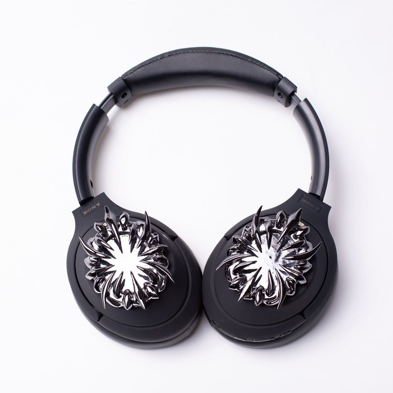 May include: Black over-ear headphones with a silver, spiky design on each earcup. The headphones have the word "SONY" printed on each earcup.