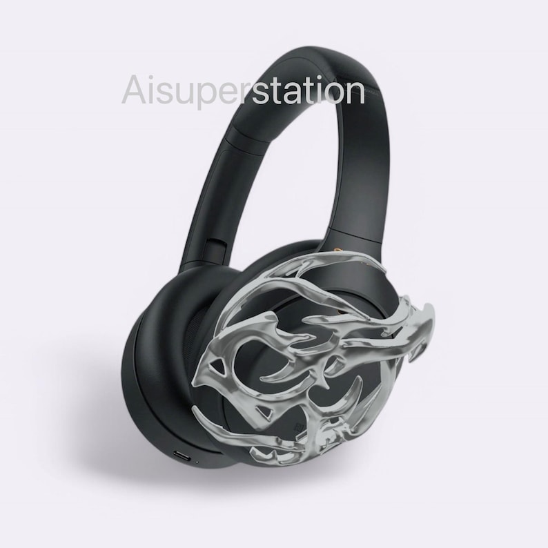 May include: Black over-ear headphones with a silver decorative design on one earcup. The design resembles a stylized branch or vine.