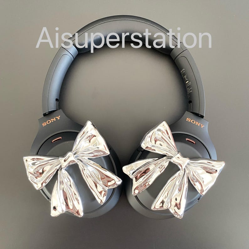 Pu&ograve; includere: Cuffie over-ear nere con dettagli a fiocco argentato. Le cuffie hanno la scritta "SONY" stampata su ogni padiglione.