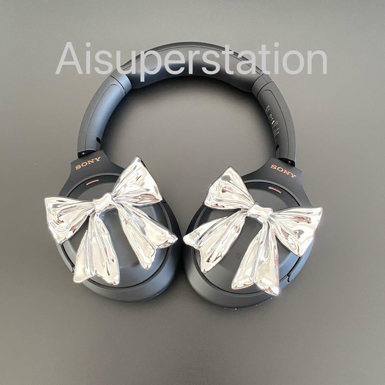 Pu&ograve; includere: Cuffie over-ear nere con fiocchi argentati attaccati a ciascun padiglione. Le cuffie hanno la scritta "SONY" stampata su ciascun padiglione.