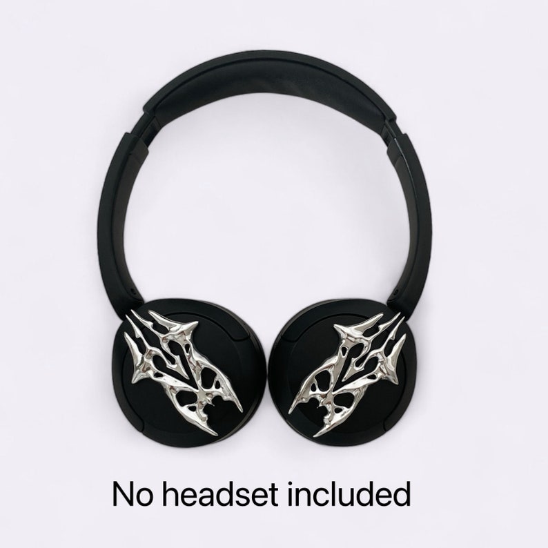 Puede incluir: Auriculares inal&aacute;mbricos negros con detalles decorativos plateados en las almohadillas. No se incluye ning&uacute;n auricular.