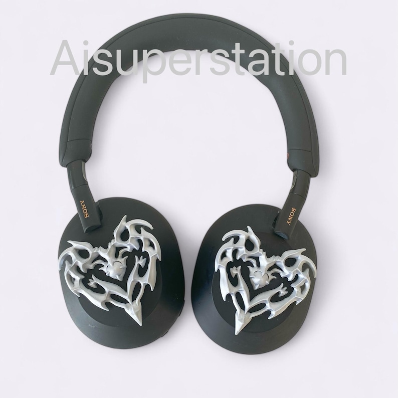 May include: Black over-ear headphones with a silver heart-shaped design on each earcup. The headphones have the word "SONY" printed on the side of each earcup.