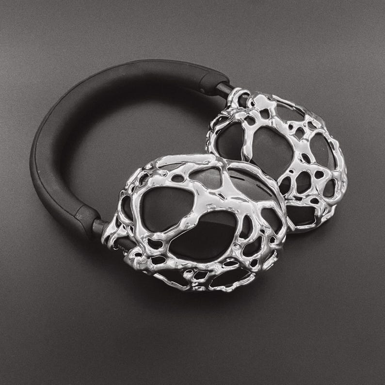 May include: Silver headphones with a unique, textured, organic-looking design. The headphones have a black headband.