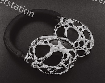 May include: Silver headphones with a unique, textured, and abstract design. The headphones have a black headband.