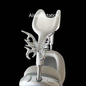 Può includere: Cuffie bianche con un design a forma di farfalla argentata sul cerchietto. Le cuffie hanno un cerchietto bianco e padiglioni con un design a rete.