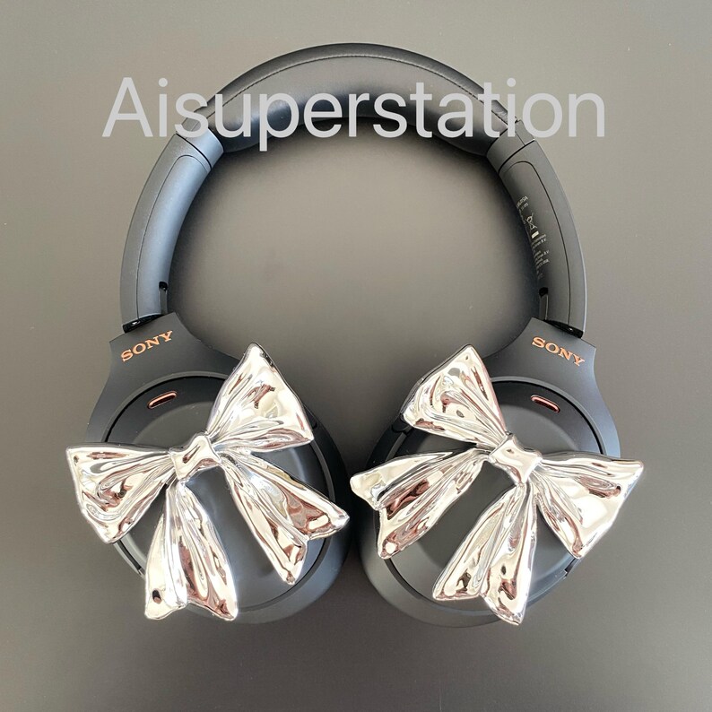 Pu&ograve; includere: Cuffie over-ear nere con dettagli a fiocco argentato. Le cuffie hanno la scritta "SONY" stampata su ogni padiglione.