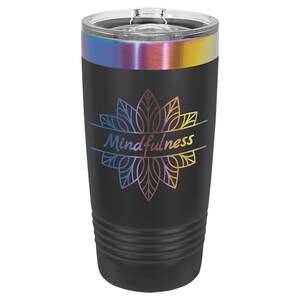 Peut inclure: Gobelet isotherme noir avec un couvercle transparent et une bande arc-en-ciel sur le dessus. Le gobelet présente un motif floral avec le mot "Mindfulness" dans un dégradé de couleurs.