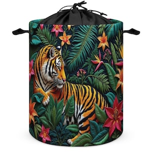 May include: A cylindrical storage bag with a drawstring closure, featuring a vibrant tiger design. The bag showcases a tiger amidst lush tropical foliage with orange, pink, and green hues. Black handles are attached to the sides.