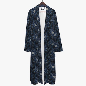 May include: A long, open-front robe with a geometric pattern in shades of blue, black, and white. The robe is hanging on a wooden hanger against a white background. The robe's design features a repeating diamond-like motif.