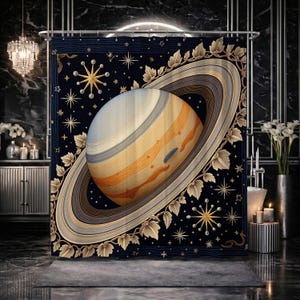 May include: A navy blue shower curtain featuring a detailed illustration of Saturn with its rings. The planet is rendered in shades of beige, orange, and blue. The curtain is decorated with gold stars and a floral border, creating a celestial theme.