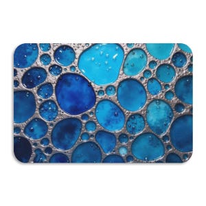 May include: A rectangular decorative piece with a mosaic design. The design features various shades of blue, from light to dark, within a silver-coloured border. The blue shapes vary in size and have a glossy appearance.