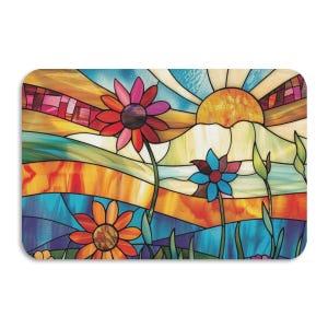May include: A rectangular stained glass design featuring a vibrant sunset over a mountain range and colorful flowers. The artwork showcases a warm color palette with shades of orange, red, blue, and yellow, creating a cheerful and artistic aesthetic.