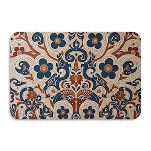 May include: Rectangular decorative mat with a symmetrical floral pattern. The design features blue, brown, and cream-colored flowers and swirling vines. The mat has rounded corners and a neutral background.