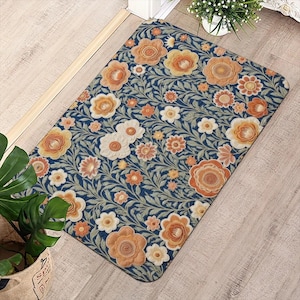 Puede incluir: Una alfombrilla rectangular con fondo azul oscuro y un patrón denso y repetitivo de flores naranjas, amarillas y crema entrelazadas con enredaderas de hojas de color verde claro. La alfombrilla tiene esquinas redondeadas y superficie lisa.