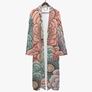 Peut inclure: Longue robe ouverte sur le devant, ornée d'un motif floral dans les tons de rose, de bleu et de violet. La robe est suspendue à un cintre en bois sur fond blanc. Le motif floral présente de grandes fleurs stylisées.