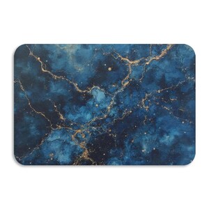 Op de afbeelding: Een rechthoekige muismat met een donkerblauw en goud marmerontwerp. De mat heeft een wervelend patroon van diepblauw en gouden aderen, waardoor een hemelse of kosmische esthetiek ontstaat. De hoeken zijn afgerond.