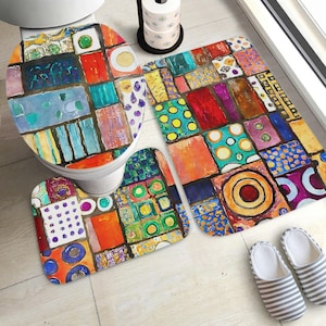 May include: A bathroom set consisting of a toilet seat cover, a rectangular bath mat, and a contour rug, all featuring a vibrant, multi-colored geometric pattern of squares, circles, and rectangles in shades of red, blue, yellow, and purple.