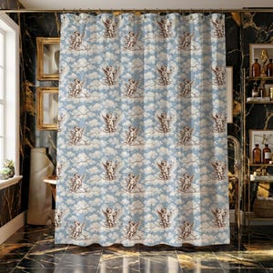 Può includere: Tenda da doccia azzurra con un motivo ripetuto di cherubini sulle nuvole. I cherubini sono color seppia e le nuvole sono bianche. La tenda è in un bagno con pavimento in marmo nero e oro.