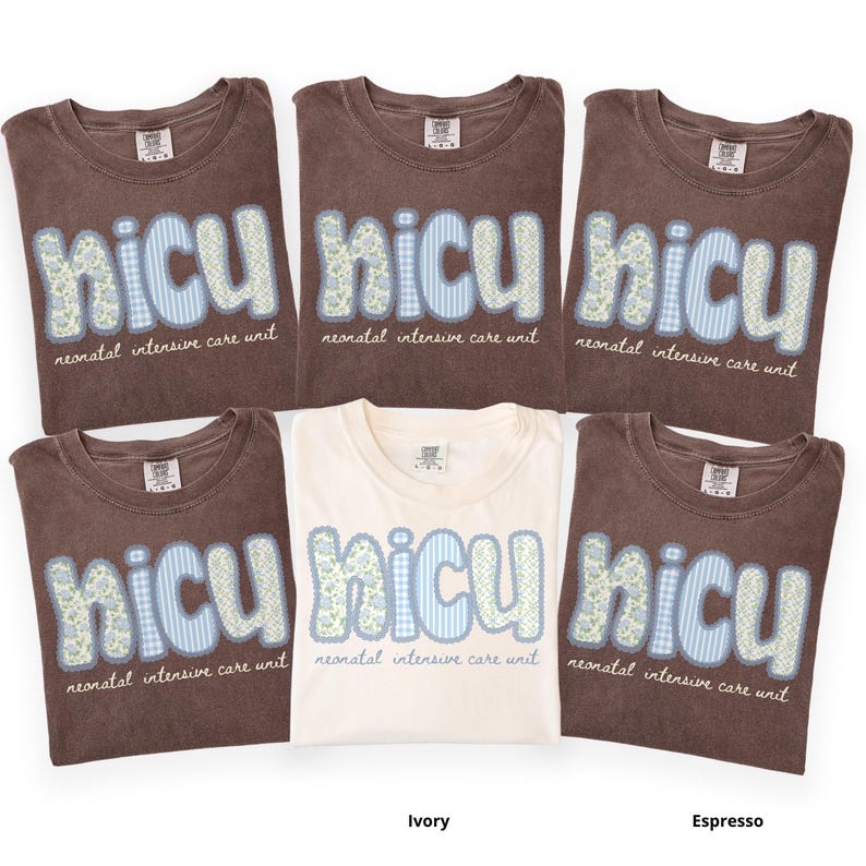 May include: A collection of folded t-shirts in ivory and espresso colors. Each shirt features the word "NICU" in a patchwork design with floral and gingham patterns, along with the text "neonatal intensive care unit".