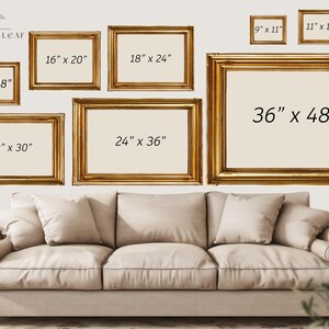May include: A white wall with a variety of gold picture frames of different sizes. The frames are arranged in a staggered pattern. The frames are labeled with their dimensions in inches. The frames are hanging above a white couch.