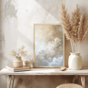 Peut inclure: Une impression encadr&eacute;e d'un ciel nuageux dans des tons beige et bleu, expos&eacute;e sur une &eacute;tag&egrave;re en bois clair avec un vase de fleurs blanches et un petit objet d&eacute;coratif.