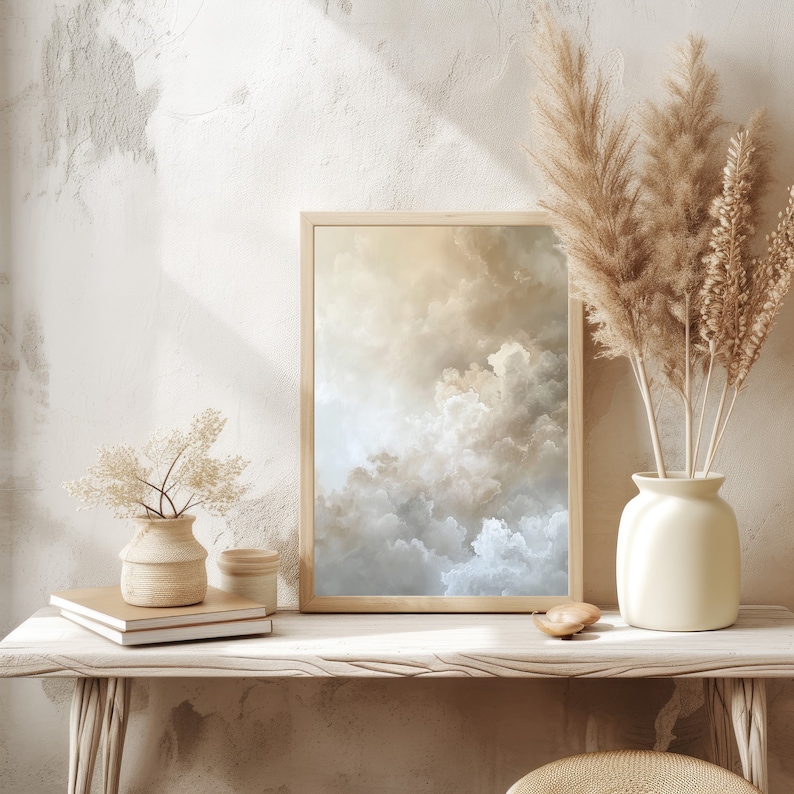 Peut inclure: Une impression encadr&eacute;e d'un ciel nuageux dans des tons beige et bleu, expos&eacute;e sur une &eacute;tag&egrave;re en bois clair avec un vase de fleurs blanches et un petit objet d&eacute;coratif.