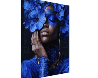 May include: A canvas art print featuring a portrait of a person with dark skin, adorned with vibrant blue floral elements. The person's face is partially covered by large blue flowers and blue face paint. Gold earrings and rings add a touch of elegance.