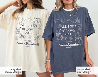 May include: Two oversized t-shirts, one ivory and one denim, featuring a beach-themed graphic. The design includes the text "ALL I SEA IS LOVE," palm trees, seashells, and the phrase "Emma's Bachelorette, Miami, FL."