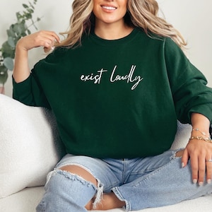May include: A dark green sweatshirt with the text "exist loudly" in white script.