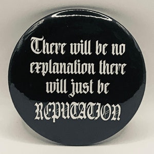 以下が含まれることがあります： ゴシック調のフォントで「There will be no explanation there will just be REPUTATION」と白い文字が書かれた、円形の黒いピンバッジ。バッジは光沢のある仕上げで、滑らかで丸みを帯びたエッジが特徴であり、コントラストの高いデザインとなっています。