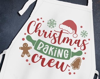 May include: White apron with the text "Christmas Baking Crew" in red and green lettering. The apron features a gingerbread man, a rolling pin, a Christmas tree, and a Santa hat.