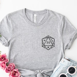 May include: Gray t-shirt with a black and white graphic of a twenty-sided die on the front.