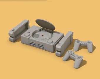 May include: A gray video game console with an open disc tray, two controllers, and two side pieces. The console has a red button and several buttons. The items are arranged on a yellow background.