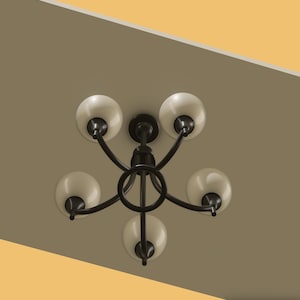 Op de afbeelding: Een zwarte kroonluchter met vijf lampen en cr&egrave;mekleurige bolvormige kappen. De armatuur is gemonteerd op een bruin plafond, met een contrasterend geel-oranje gedeelte in de hoek. De armen van de kroonluchter buigen naar buiten.