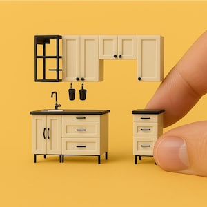 Könnte beinhalten: Ein Miniatur-Küchenset mit weißen Schränken, einer schwarzen Arbeitsplatte und einem kleinen Spülbecken. Das Set enthält einen Schrank mit drei Schubladen und einen Schrank mit zwei Türen. Außerdem gibt es einen kleinen Schrank mit drei Schubladen.