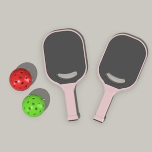 May include: Two pink pickleball paddles with black faces and two balls, one red and one green.