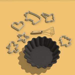 Könnte beinhalten: Eine schwarze Backform mit geriffeltem Rand, ein Kartoffelstampfer aus Holz und verschiedene Metall-Ausstecher in Form eines Sterns, Herzens, Lebkuchenmanns, Weihnachtsbaums und eines Hauses auf gelbem Hintergrund.