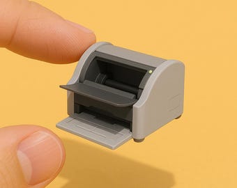 May include: A gray and black desktop scanner with a paper tray and a lid that opens to reveal the scanning area.