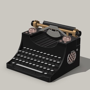 Puede incluir: Una máquina de escribir negra y dorada de estilo vintage con un teclado completo de teclas blancas. La máquina de escribir presenta detalles dorados, incluido el retorno del carro y las perillas. El diseño incluye un elemento circular similar a un altavoz en el lateral.