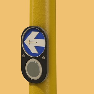 May include: A black button with a white arrow pointing to the left, mounted on a yellow pole. The button is labeled with a blue circle and a white arrow.