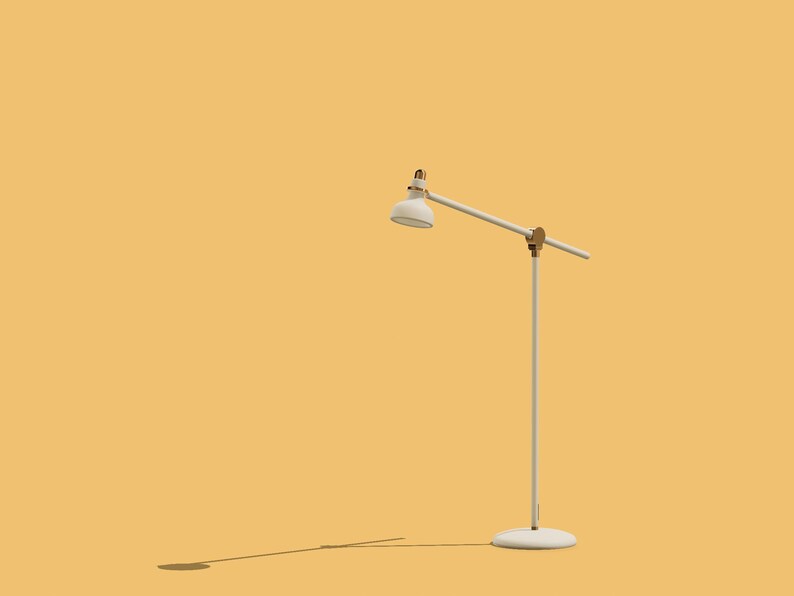 May include: A white floor lamp with a white shade and a gold accent. The lamp is on a yellow background.