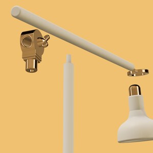 May include: A white desk lamp with a gold-colored base and a white shade. The lamp is disassembled, showing the individual parts.