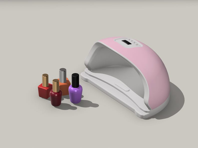 Op de afbeelding: Roze nagellamp met een digitaal timerdisplay en vier flesjes nagellak in rood, oranje, zilver en paars.