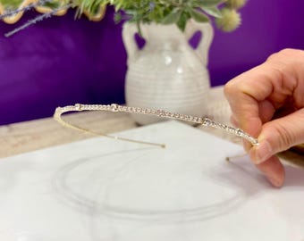 Diadema fina y sencilla de metal con pedrería.