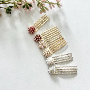 May include: A collection of six hair combs featuring clusters of small beads or crystals at the top. Four combs have gold-toned metal teeth, while two have silver-toned metal teeth. The beads vary in color, including rose gold, brown, and white.